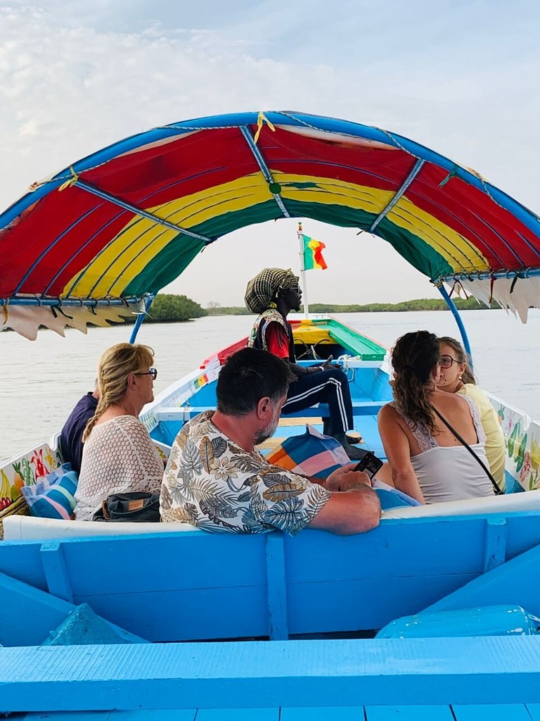 Passagers face aux bolongs, sous le taud de la pirogue