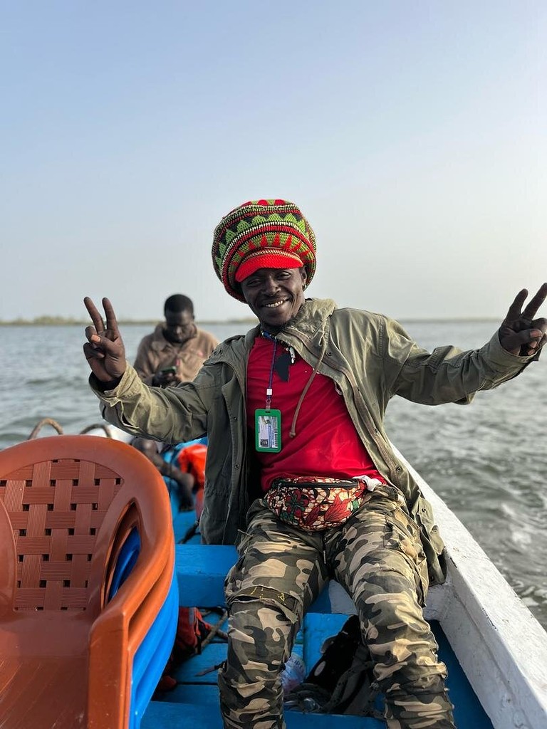 Un membre de l'équipage salue depuis la pirogue