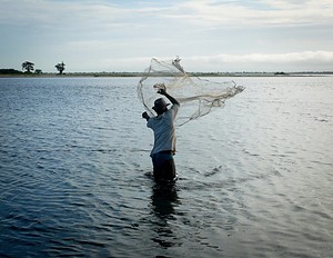 Pêcheur lançant son filet épervier