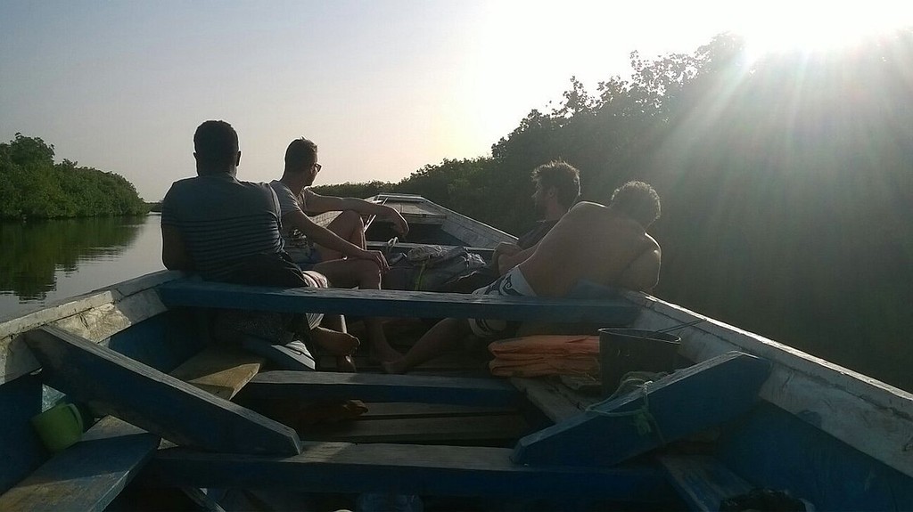 Passagers de la pirogue à contre-jour, en fin de journée
