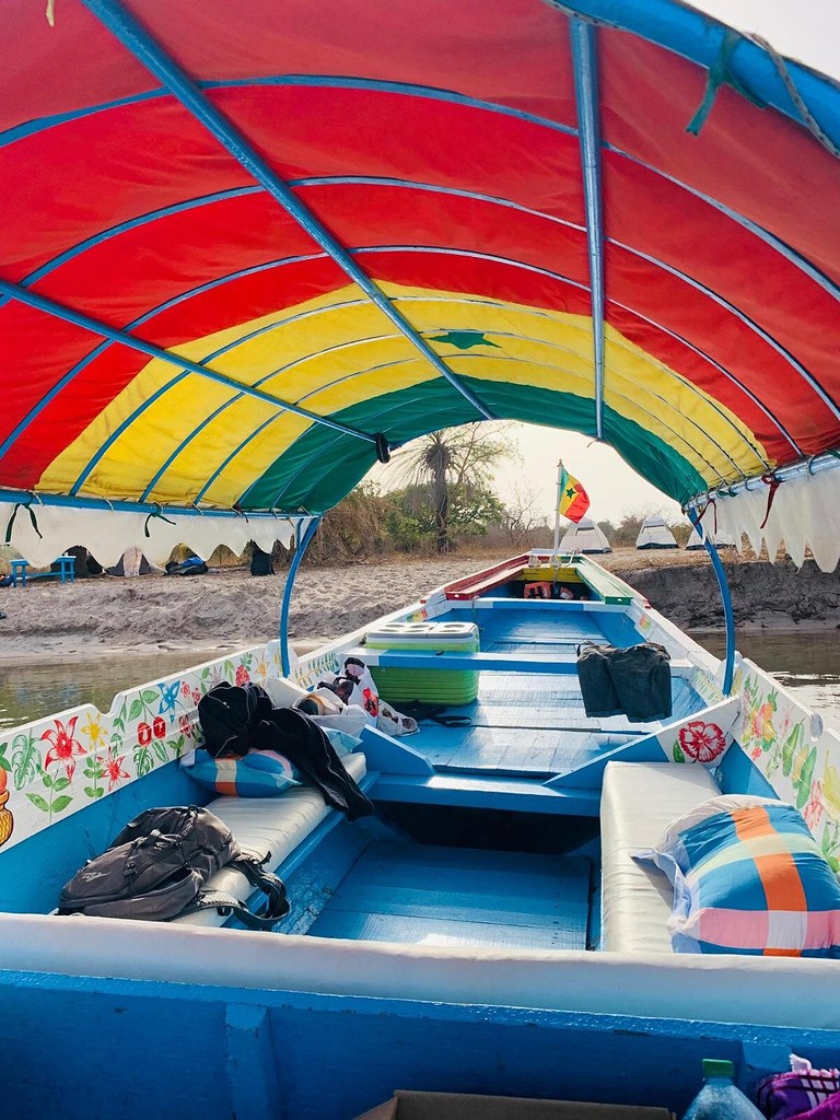 La pirogue sous son taud rouge, jaune et vert