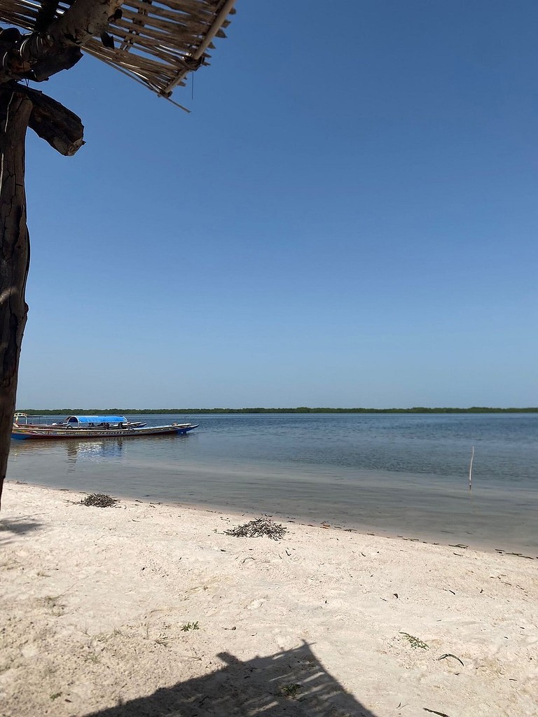 Une plage et une pirogue au loin