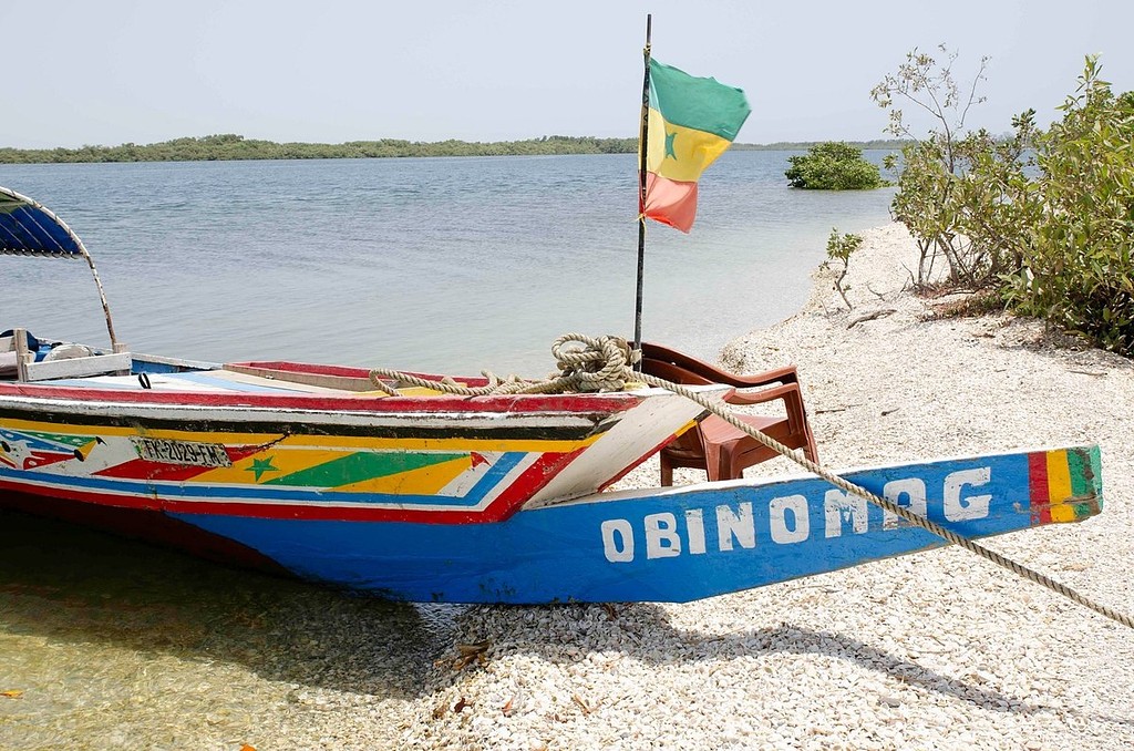 La proue OBINOMAG sur une plage de coquillages
