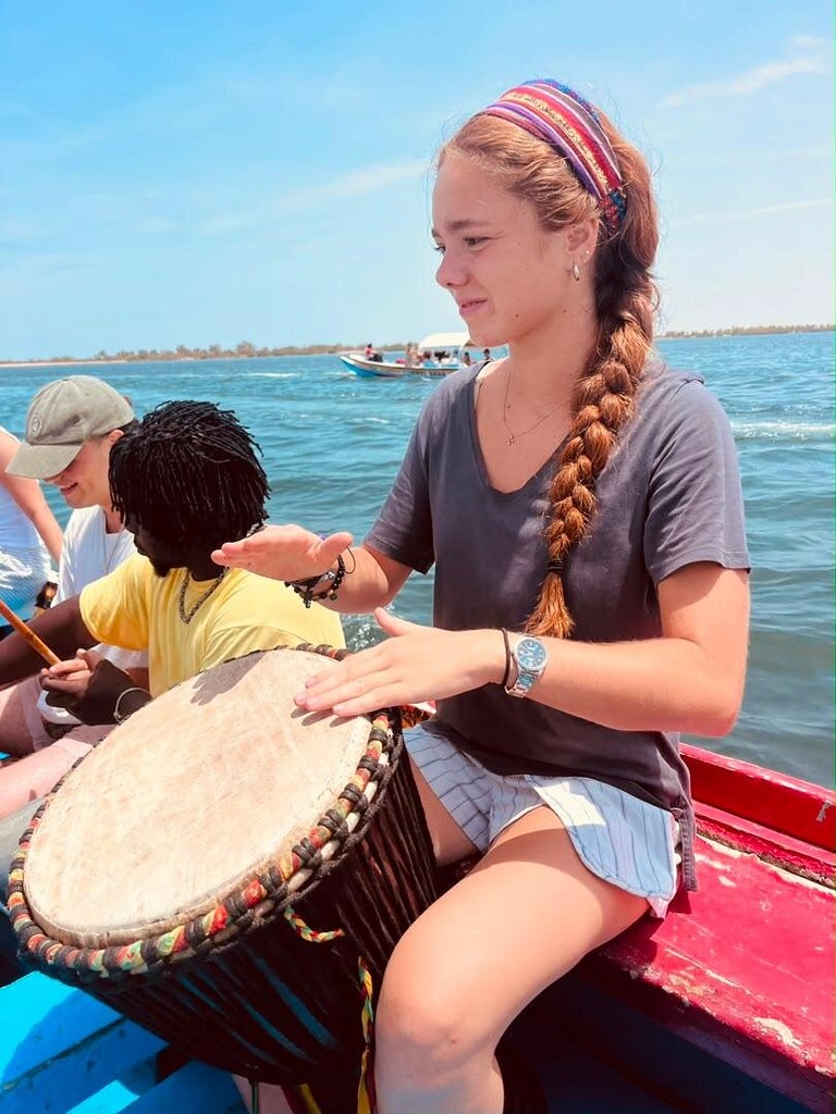 Une voyageuse s'essaie au djembé sur la pirogue
